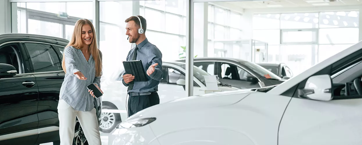 A car salesman showing a woman a new car