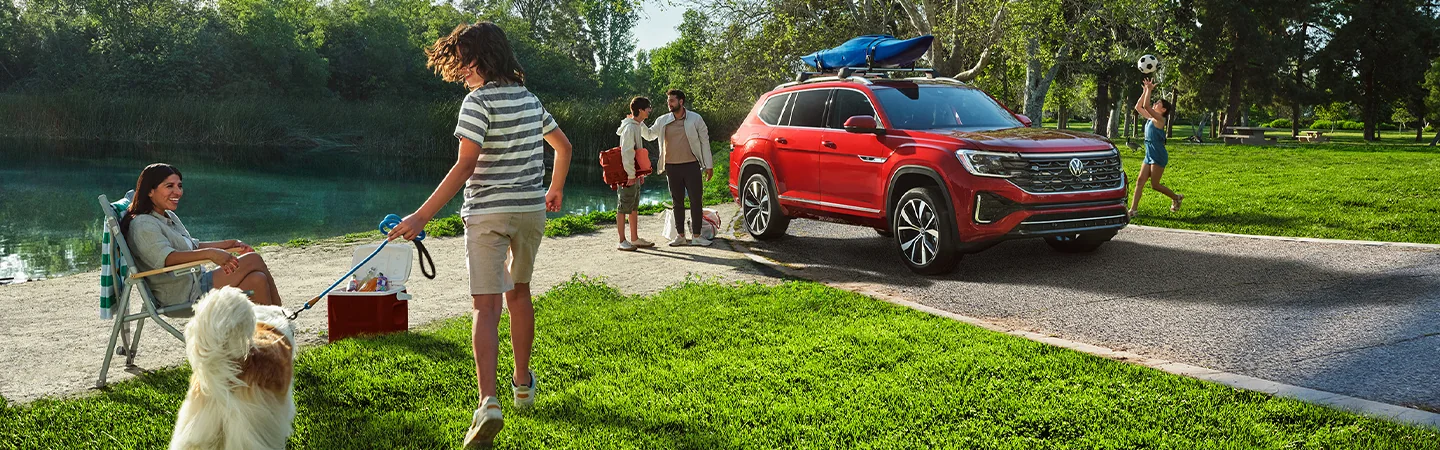 Family enjoying a 2026 Volkswagen Atlas near a lake