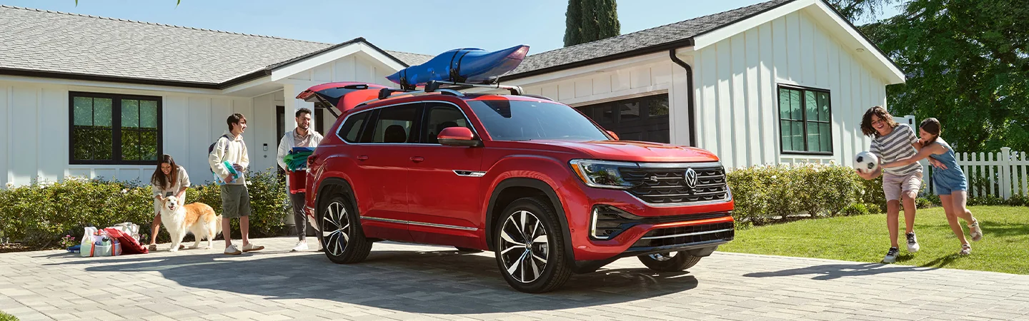 FAmily loading the 2026 Volkswagen Atlas with a kayak on the roof