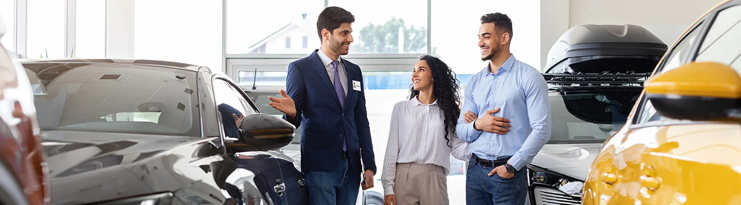 couple talking about used cars in dealership