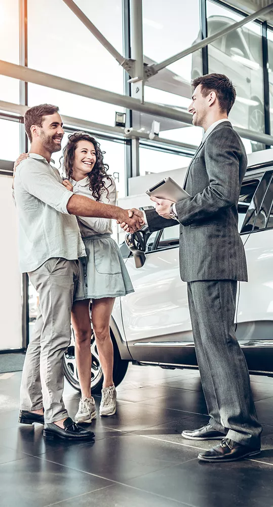Sales perosn shaking hands with Customers inside the dealership