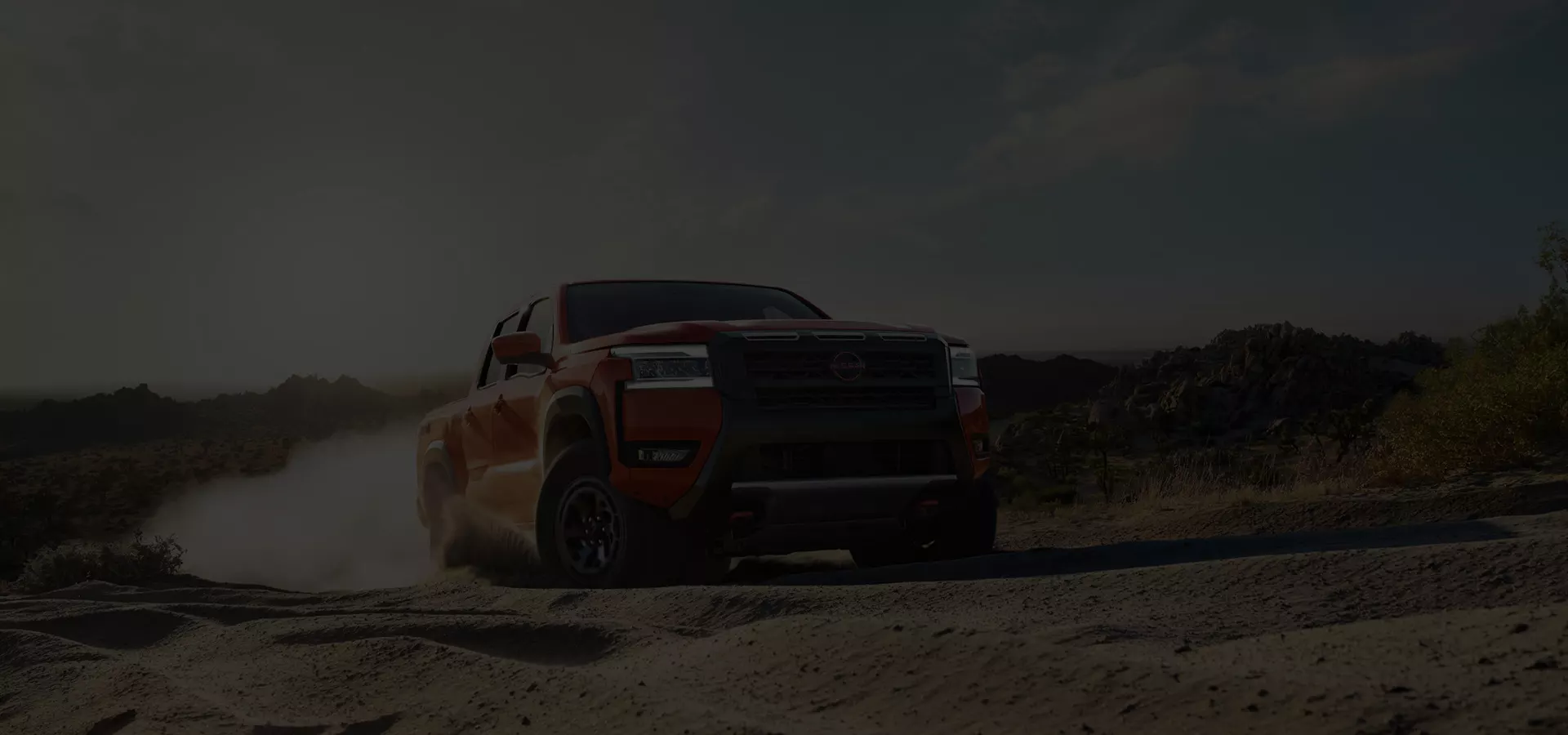 A red Nissan truck being driven off road