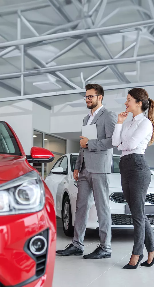 Sales person showing a customer around the dealership showroom