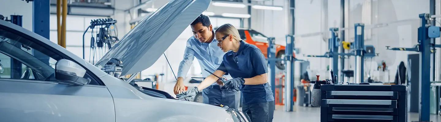 2 Service techs checking out a cars engine