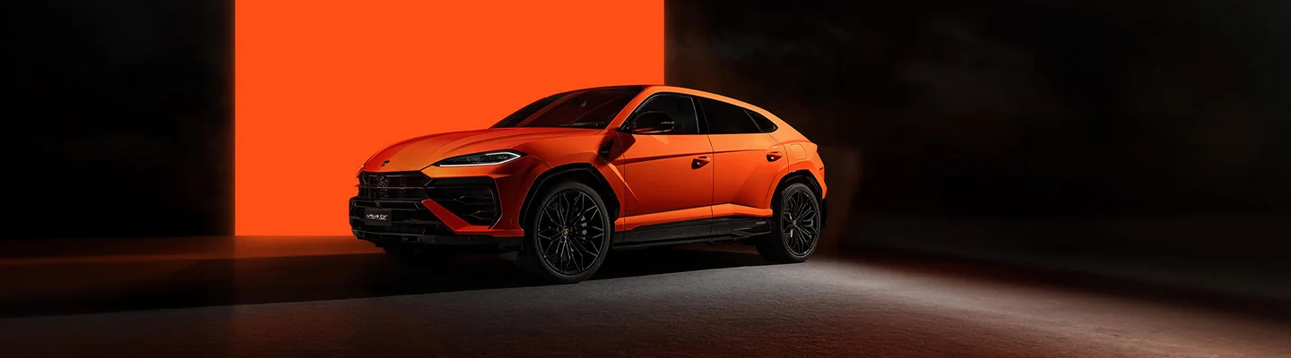 Side view of a orage the Urus SE parked in a studio setting