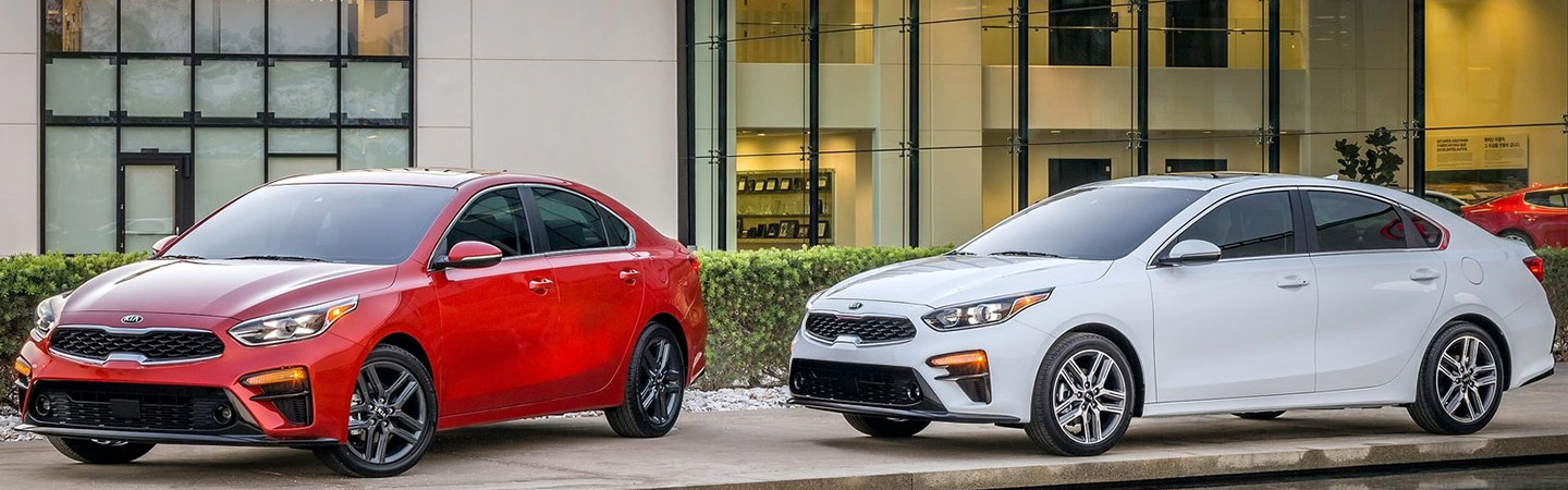 Lupient Kia red and white parked in front dealership