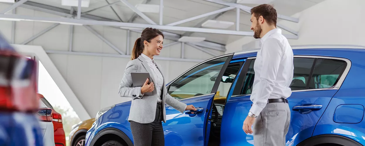 Customer being shown a new vehicle by a car sales woman