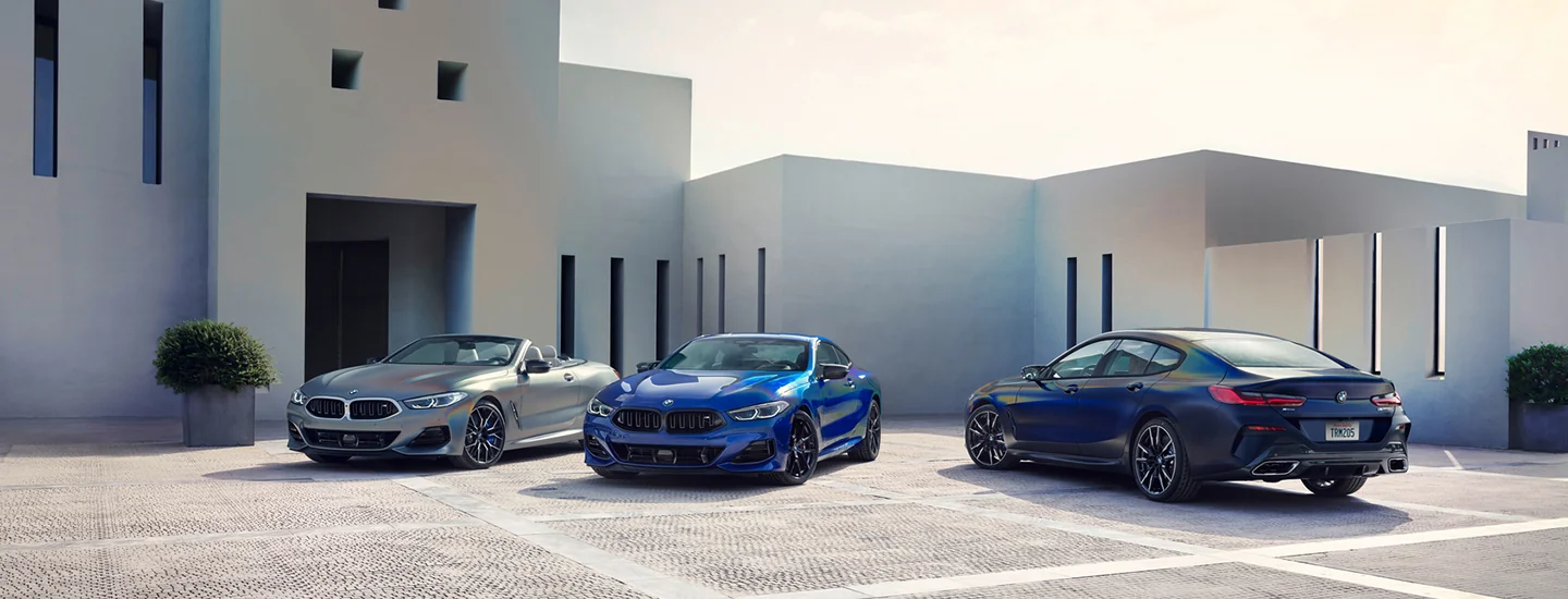 2025 BMW 8 Series Car parked in a modern architectural setting.