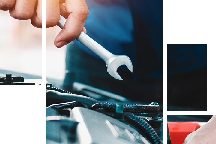 Auto mechanic holding wrench working on car