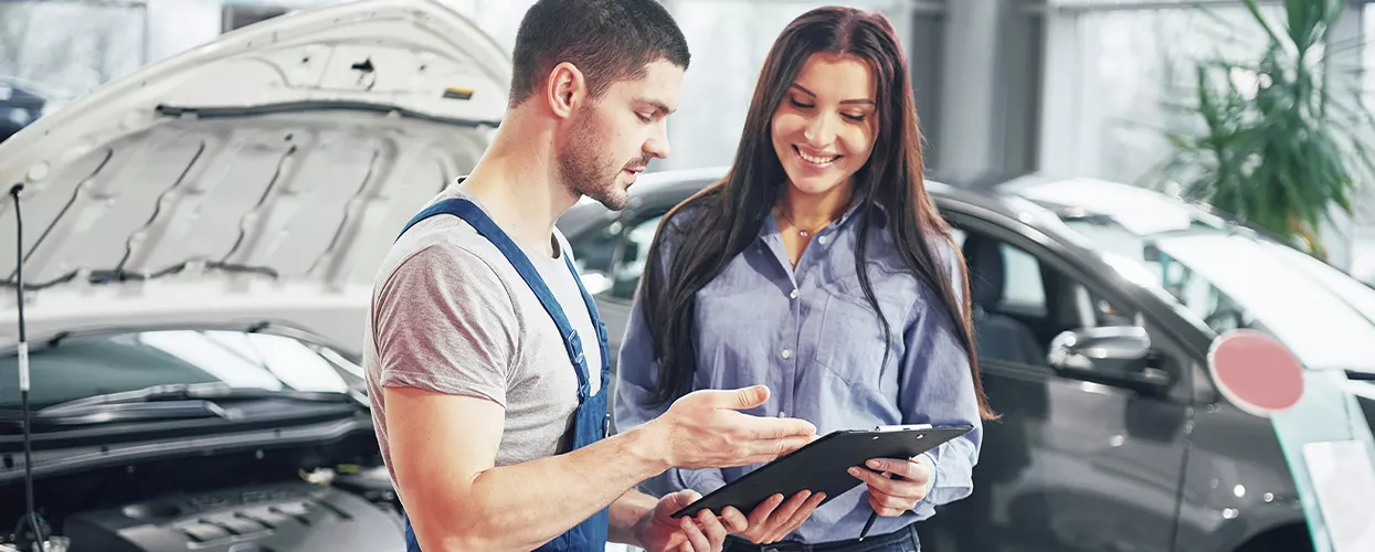 Service machanic showing a customer a clipboard