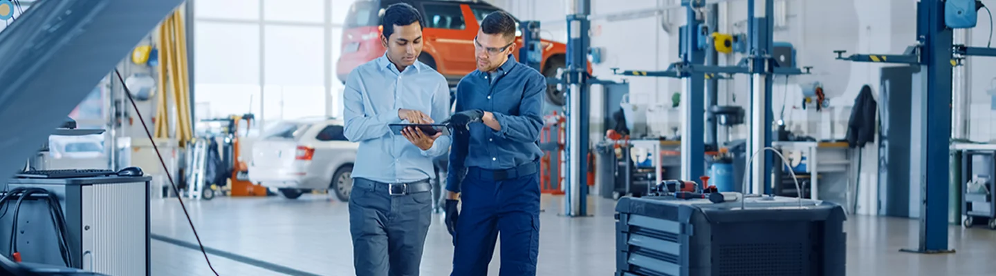 two people discussing car service looking over clipboard in service bay