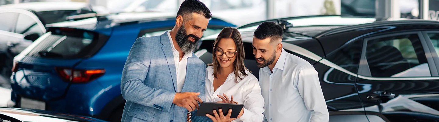 Sales person showing customers the difference between Mercedes-Benz EQS Sedan and Tesla