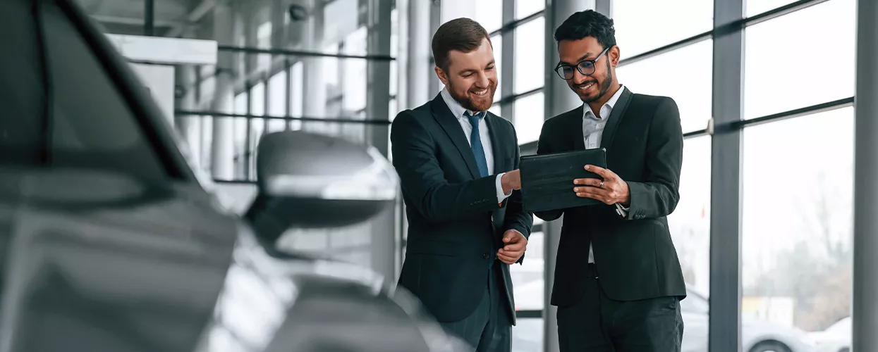 Two people looking at a tablet at a dealership