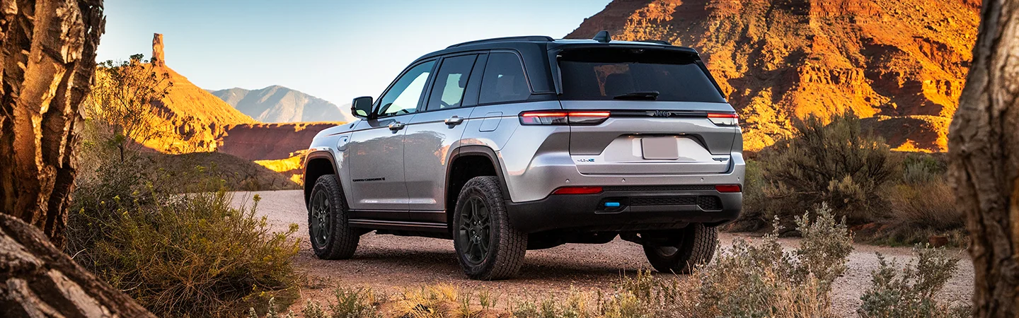2025 Jeep Grand Cherokee light gray color car parked in mountain road