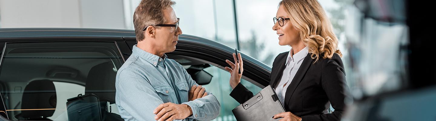 2 people talking in car showroom