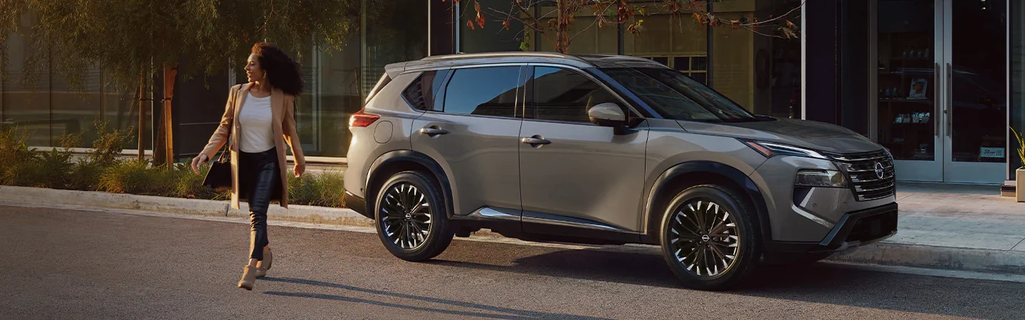 Side view of a gray parked 2024 Nissan Rogue on a city street