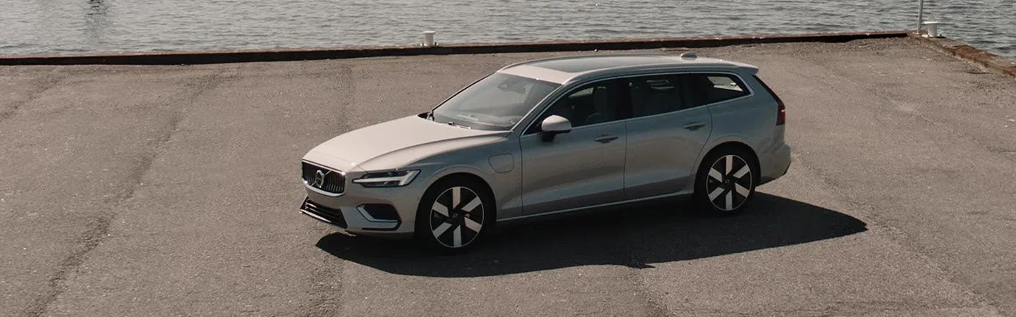 top front side view of parked 2025 Volvo V60 Cross Country Plus on a cement pier