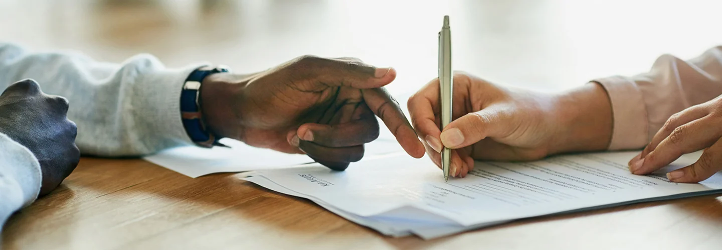 two people writing on contract
