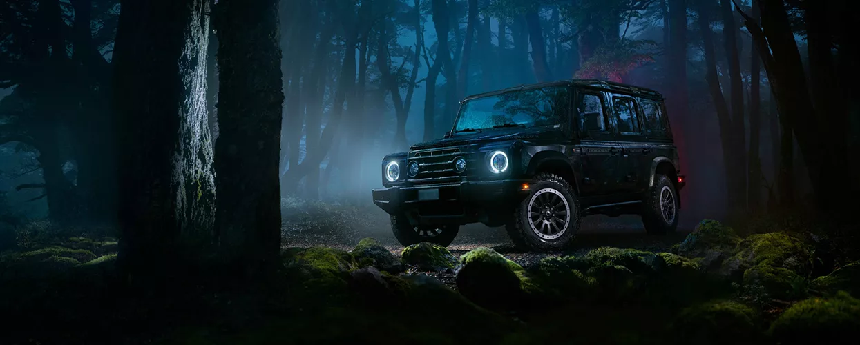 INEOS Vehicle driving on a forest path at night