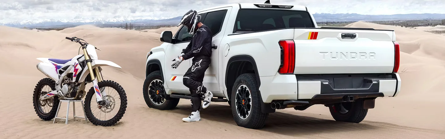 off road 2025 Toyota Tundra with dirt bike parked nearby