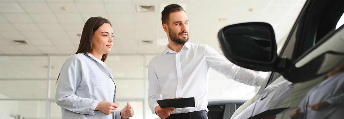 two people looking over a car snd a tablet with car specifications on it
