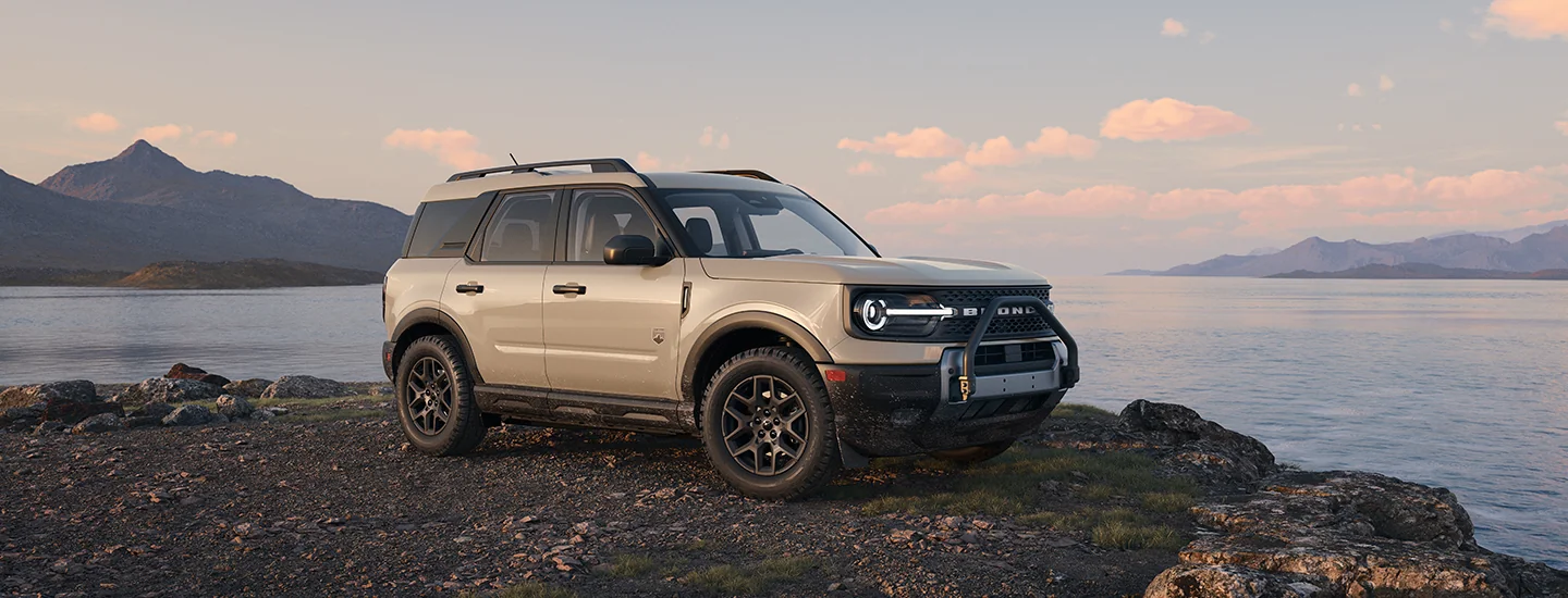 2025 Ford Bronco Sport parked by lake with mountain range in distance