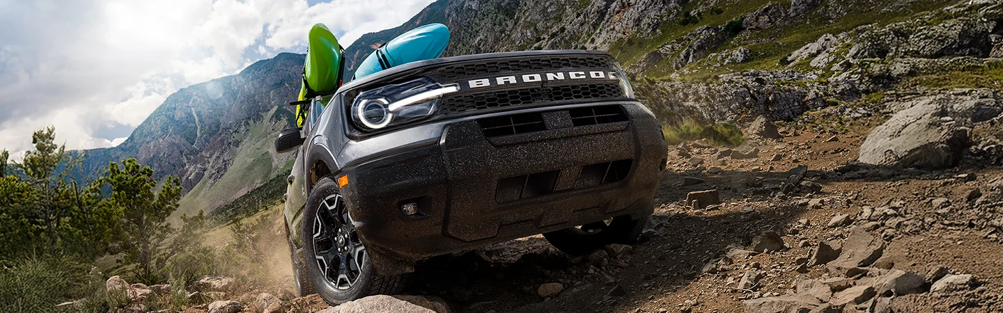 offroad view of the 2025 Ford Bronco Sport Big Bend with kayaks mounted on top going up hill