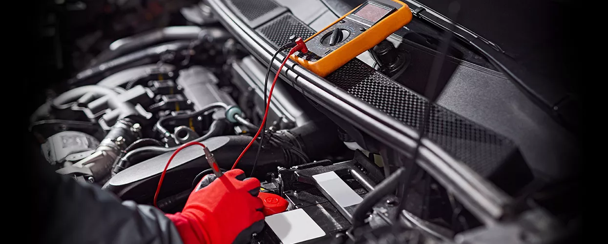 Service mechanic working under the hood of a vehicle