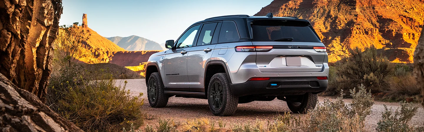 Back view of a parked 2025 Jeep Grand Cherokee with a view of mountains in the background