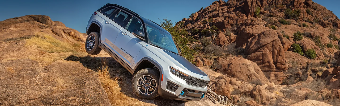 A 2025 Jeep Grand Cherokee driving downa rocky hill