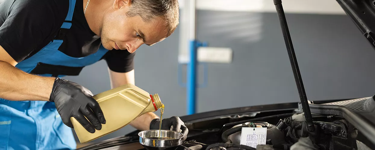 Service mechanic performing an oil change on a vehicle