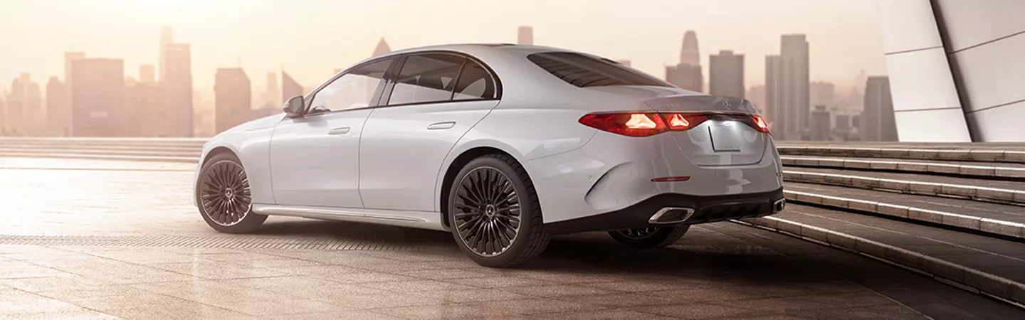 Rear view of the 2025 Mercedes-Benz E-Class with a city skyline in the background