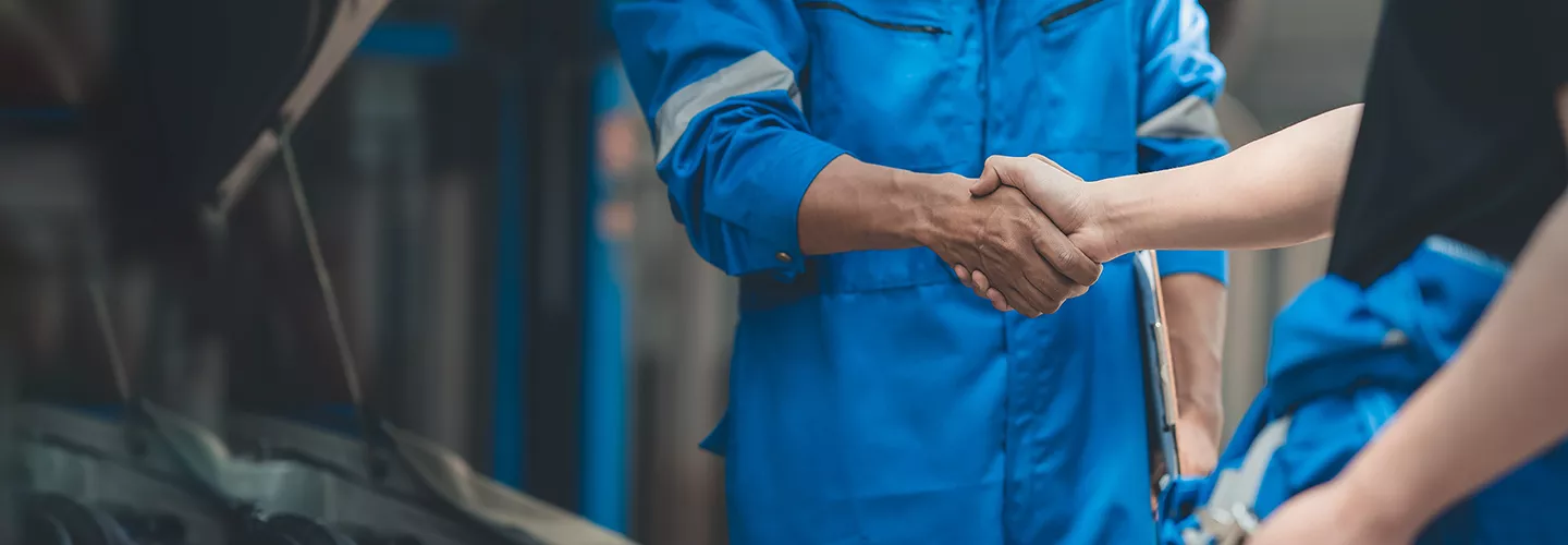 Two service mechanic shaking hands with each other