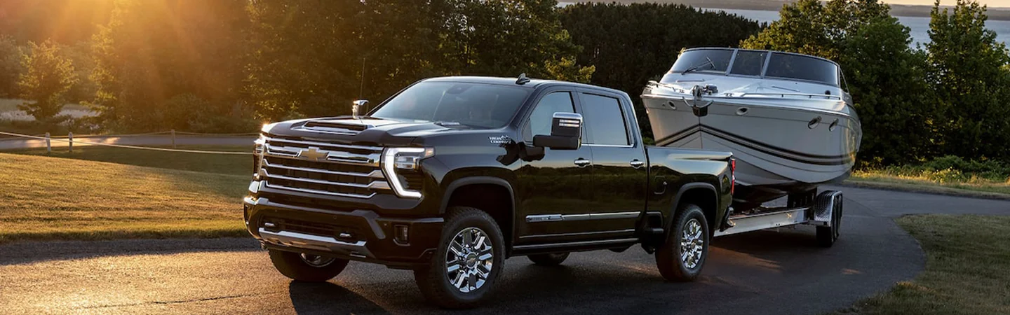 Black 2025 Chevrolet Silverado HD towing a boat