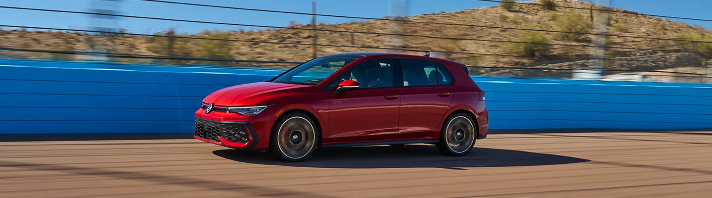a red 2025 Volkswagen Golf GTI on a track turn