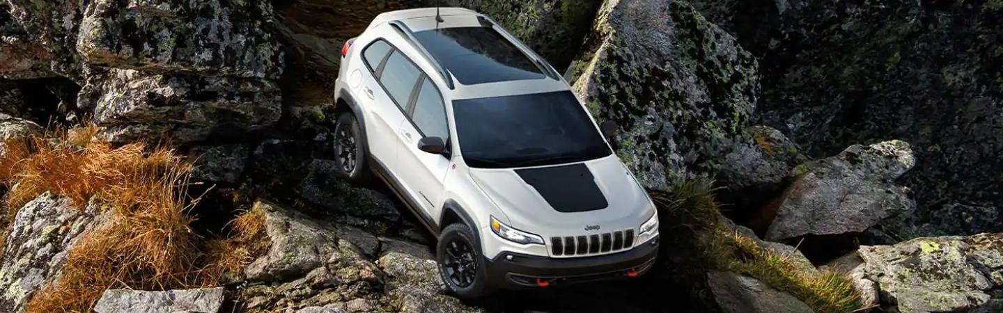 Top view of a white Jeep Cherokee traversing over boulders.