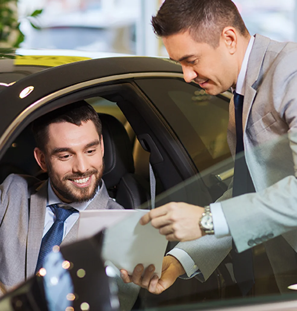 sales person showing customer specs on the new car he is checking out