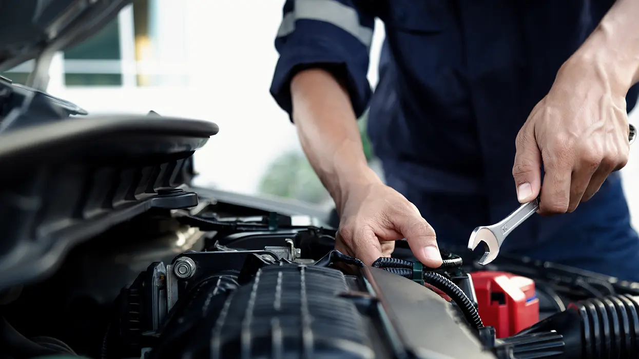 mechanic with tool in engine