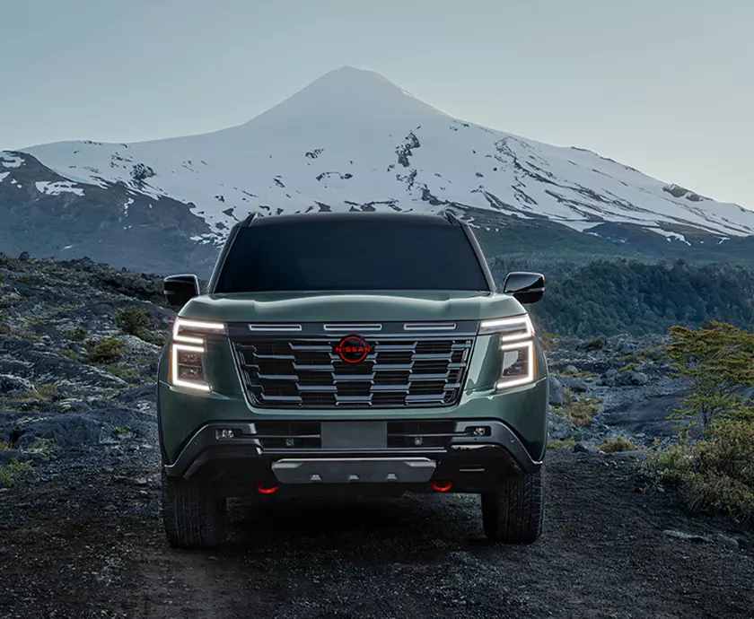 front view of a Nissan Armada parked at base of snowtop mountain