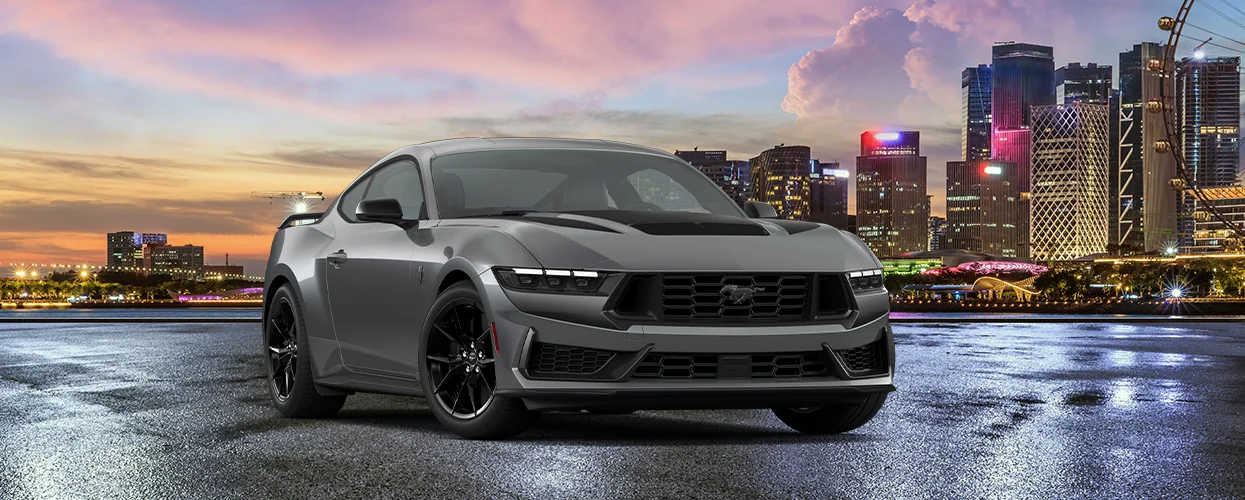 front view of a silver Mustang with city skyline in baclground