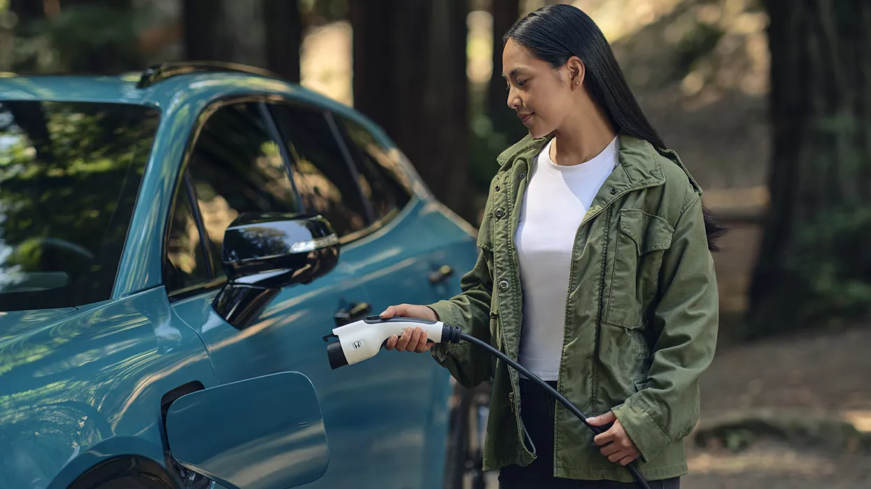 Woman charging her electric Honda vehicle