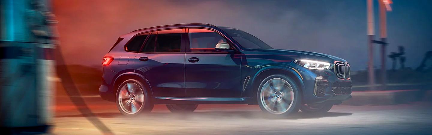 A blue 2021 BMW X5 driving