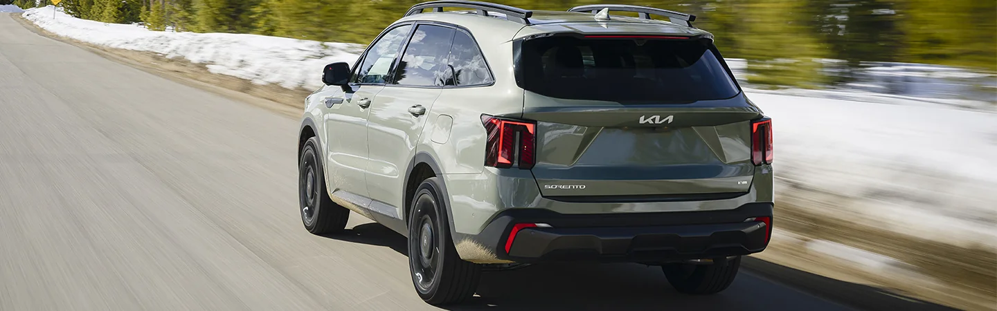 green 2025 Kia Sorento driving on hills road