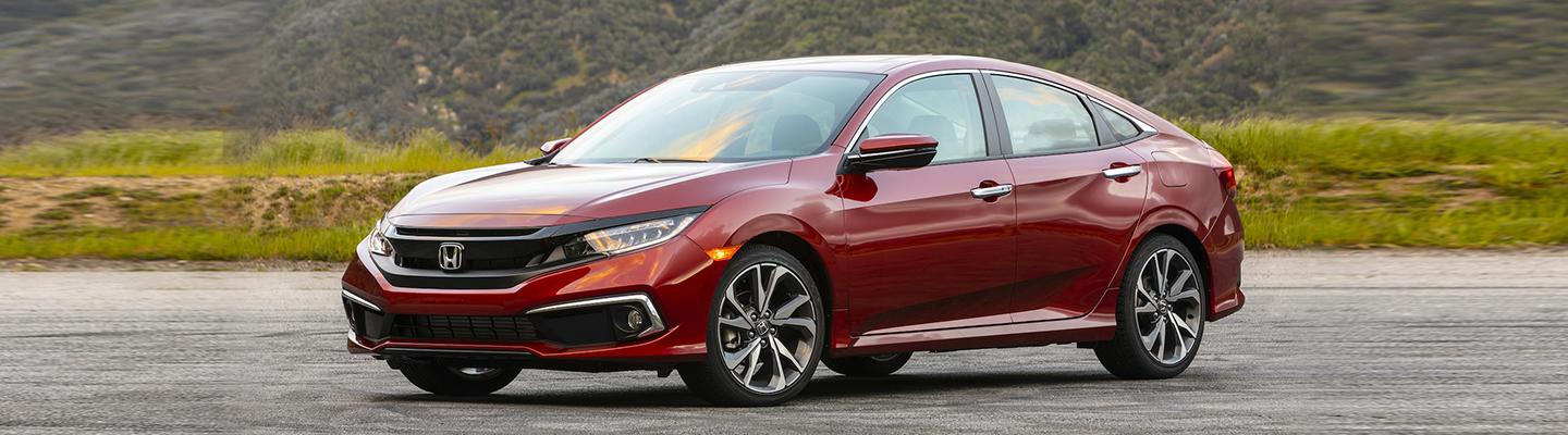 Angled side profile of a parked red Honda Civic