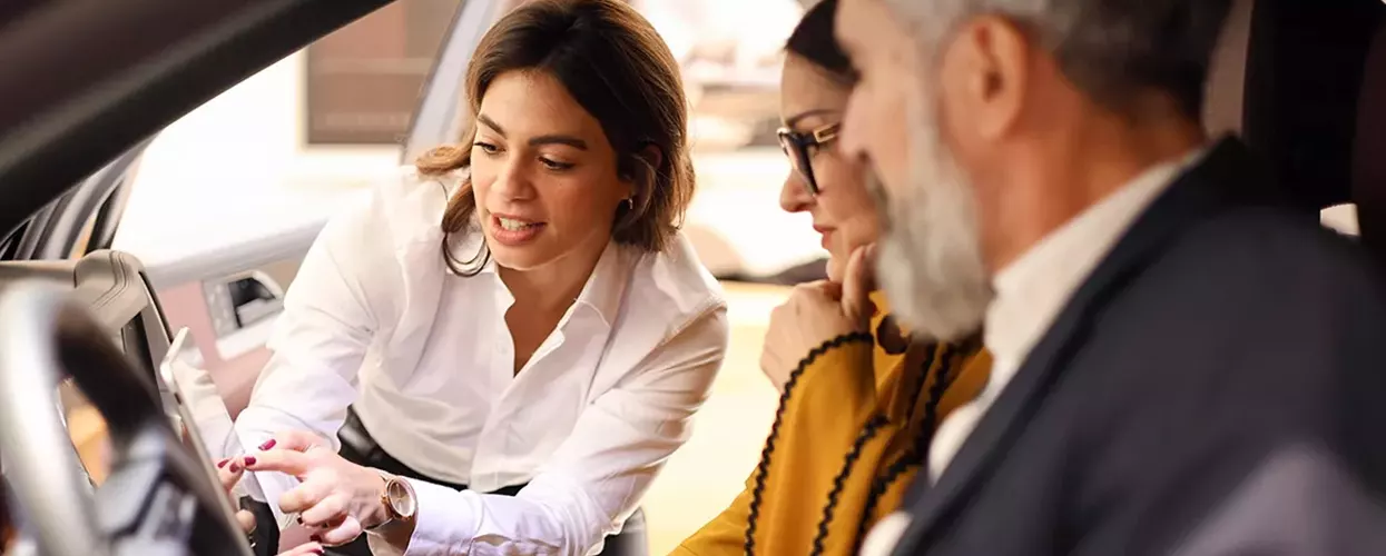 Car saleswoman showing a couple a new Lamborghini