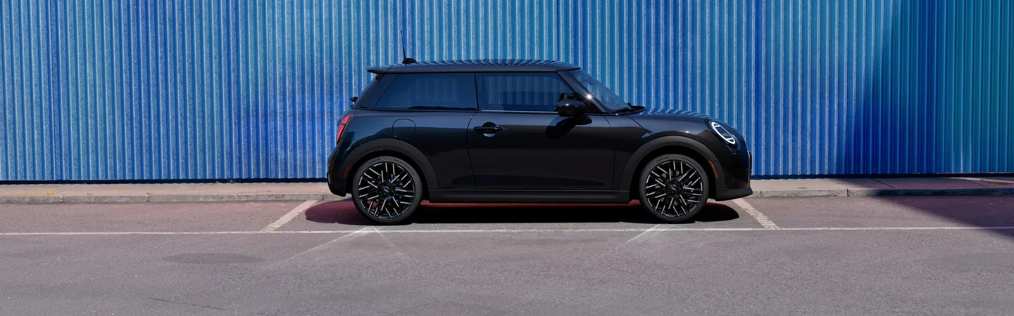 black 2025 MINI Cooper 2 Door parked by blue building
