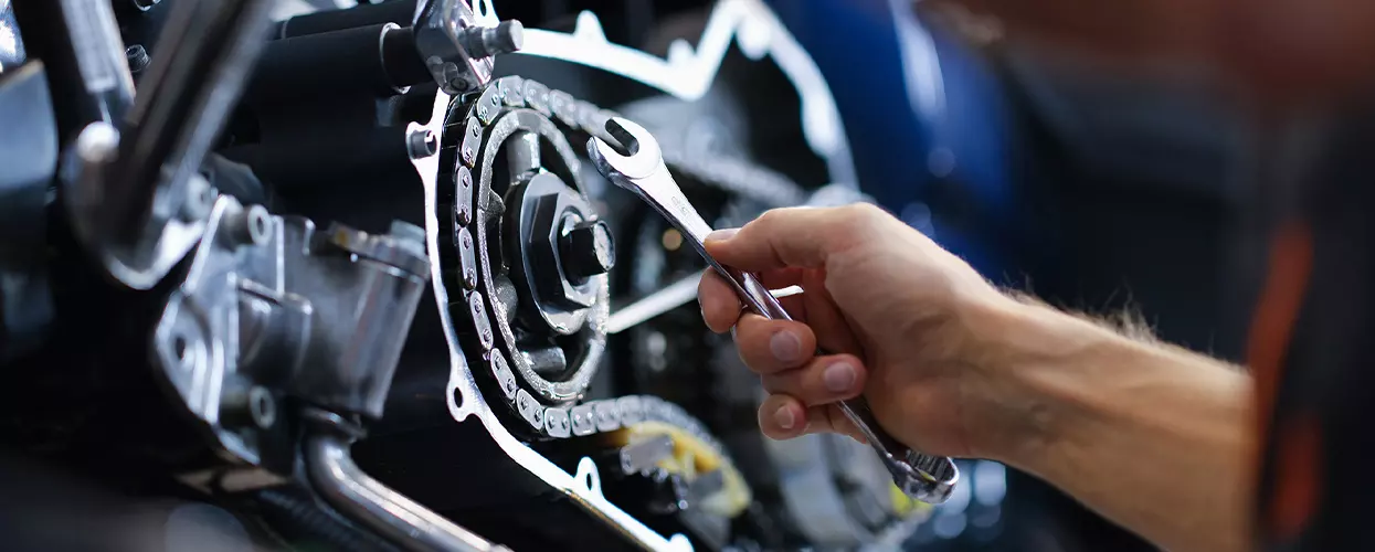 mechanic holding wrench working on an engine