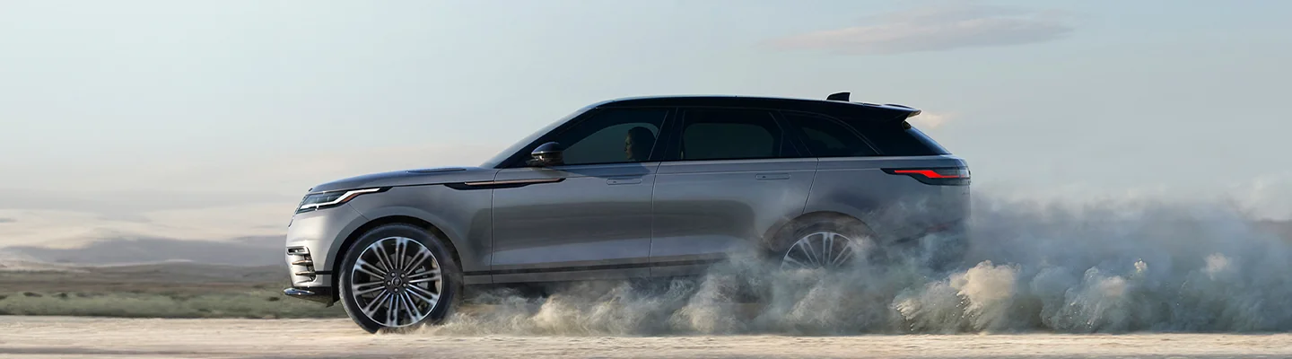 silver Land Rover drving in sand