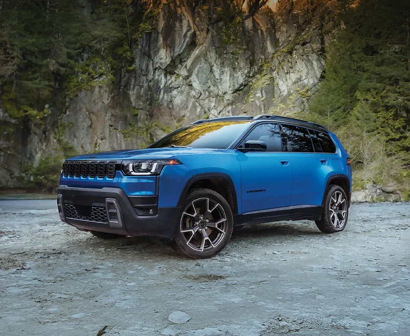a blue 2026 Jeep Cherokee parked by cliff