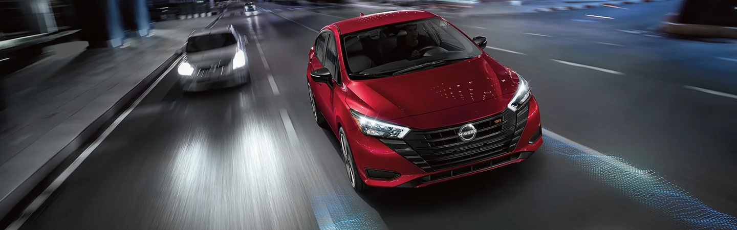 top front view of two 2025 Nissan Versa SV one silver one red in motion